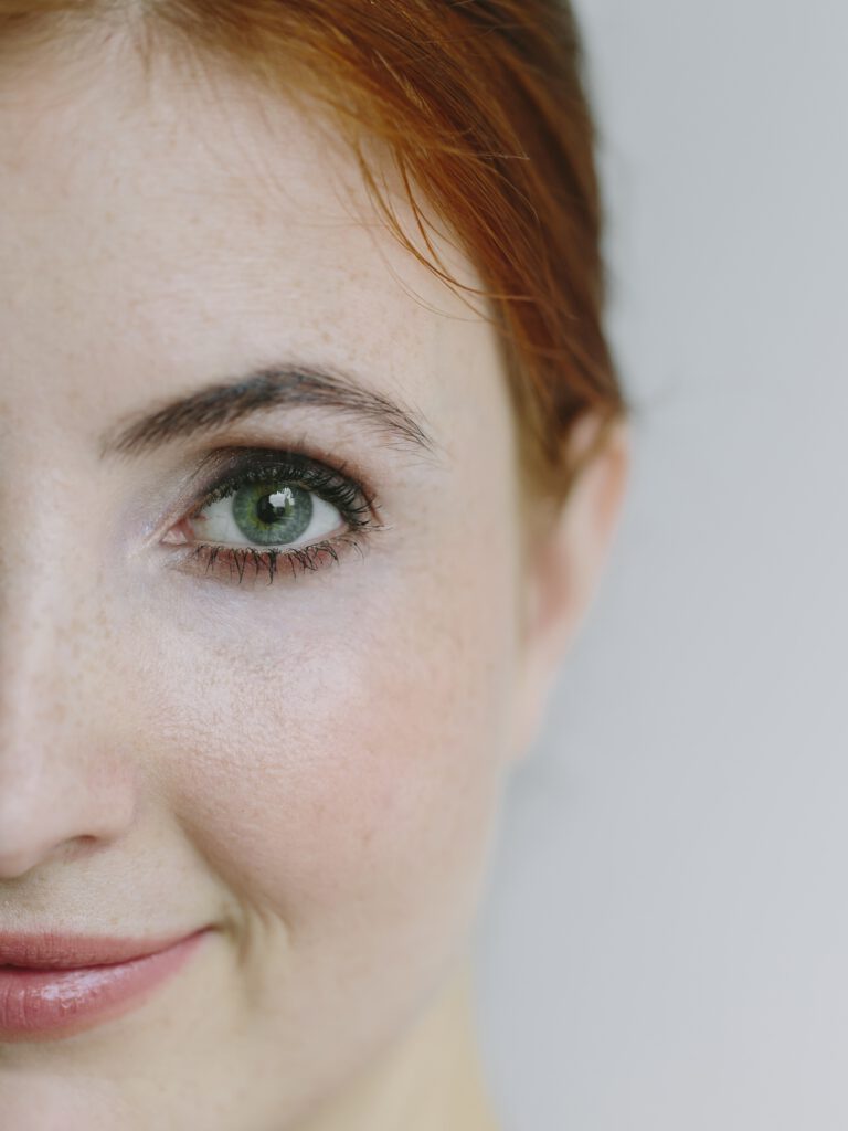 Rothaarige Frau im Anschnitt, die Hälfte des Gesichts ist sichtbar