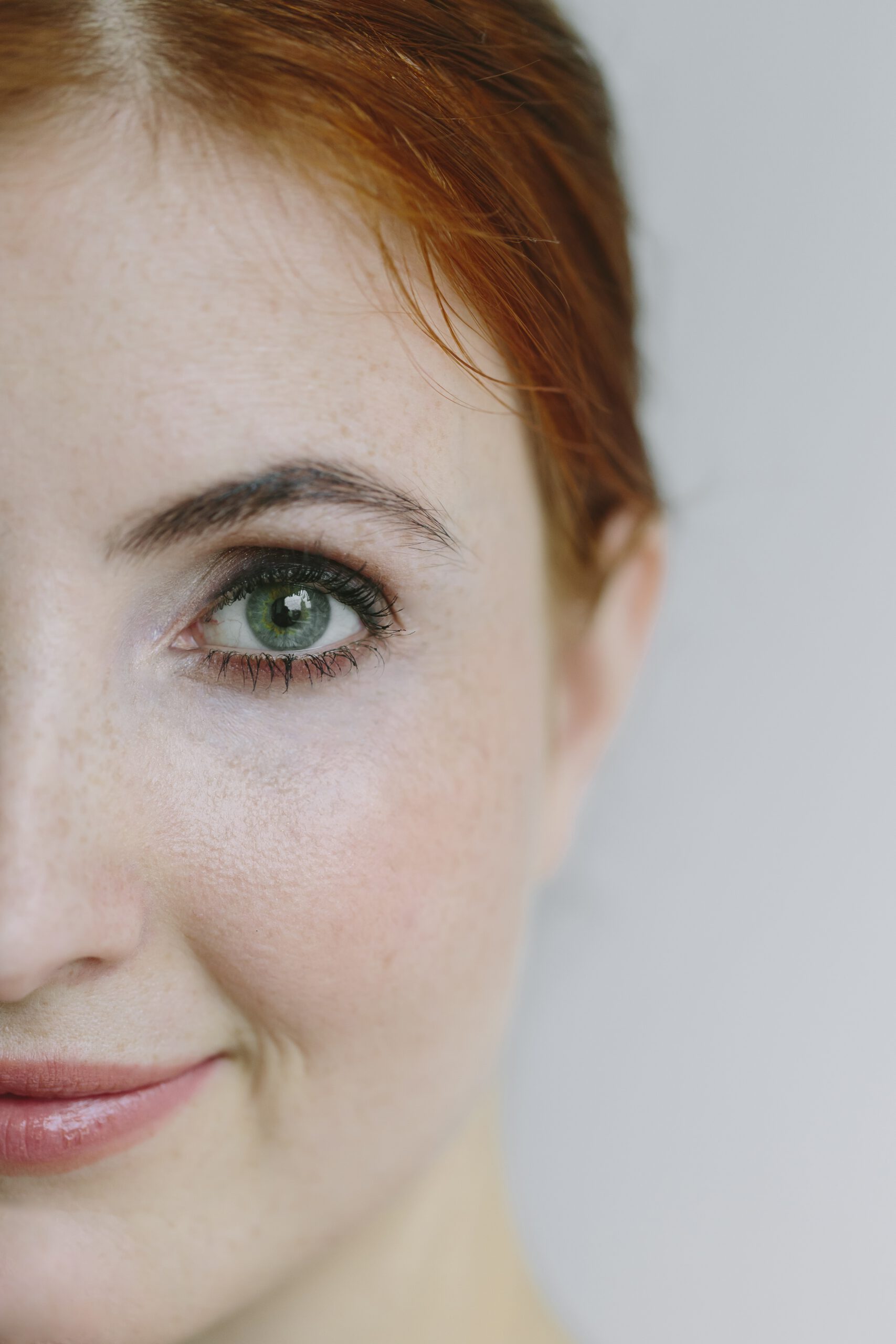 Rothaarige Frau im Anschnitt, die Hälfte des Gesichts ist sichtbar