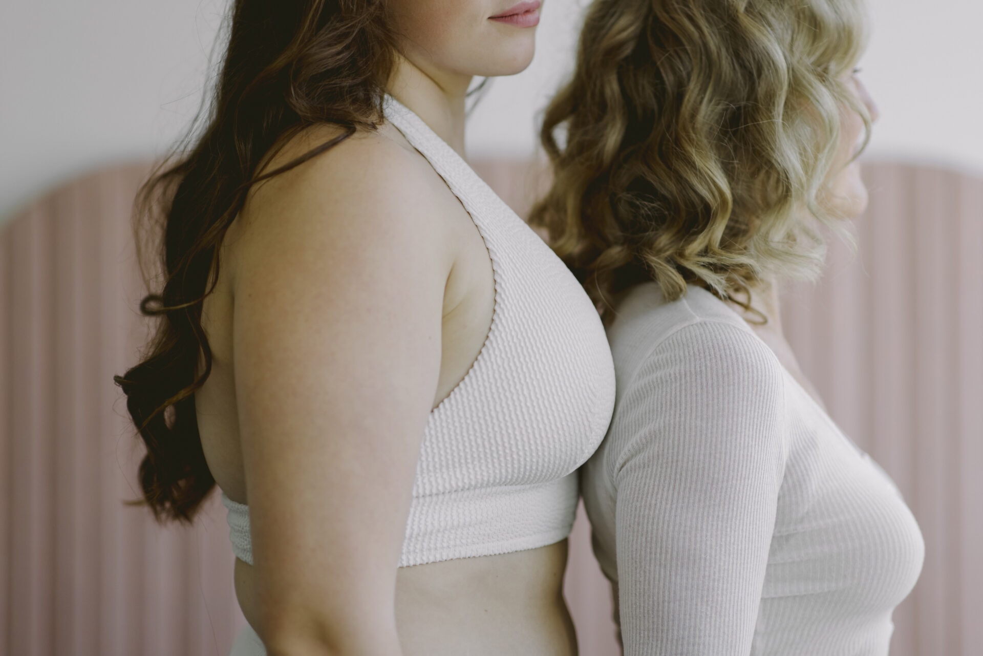 Zwei Frauen in weißen Tops seitlich stehend von Hintergrund