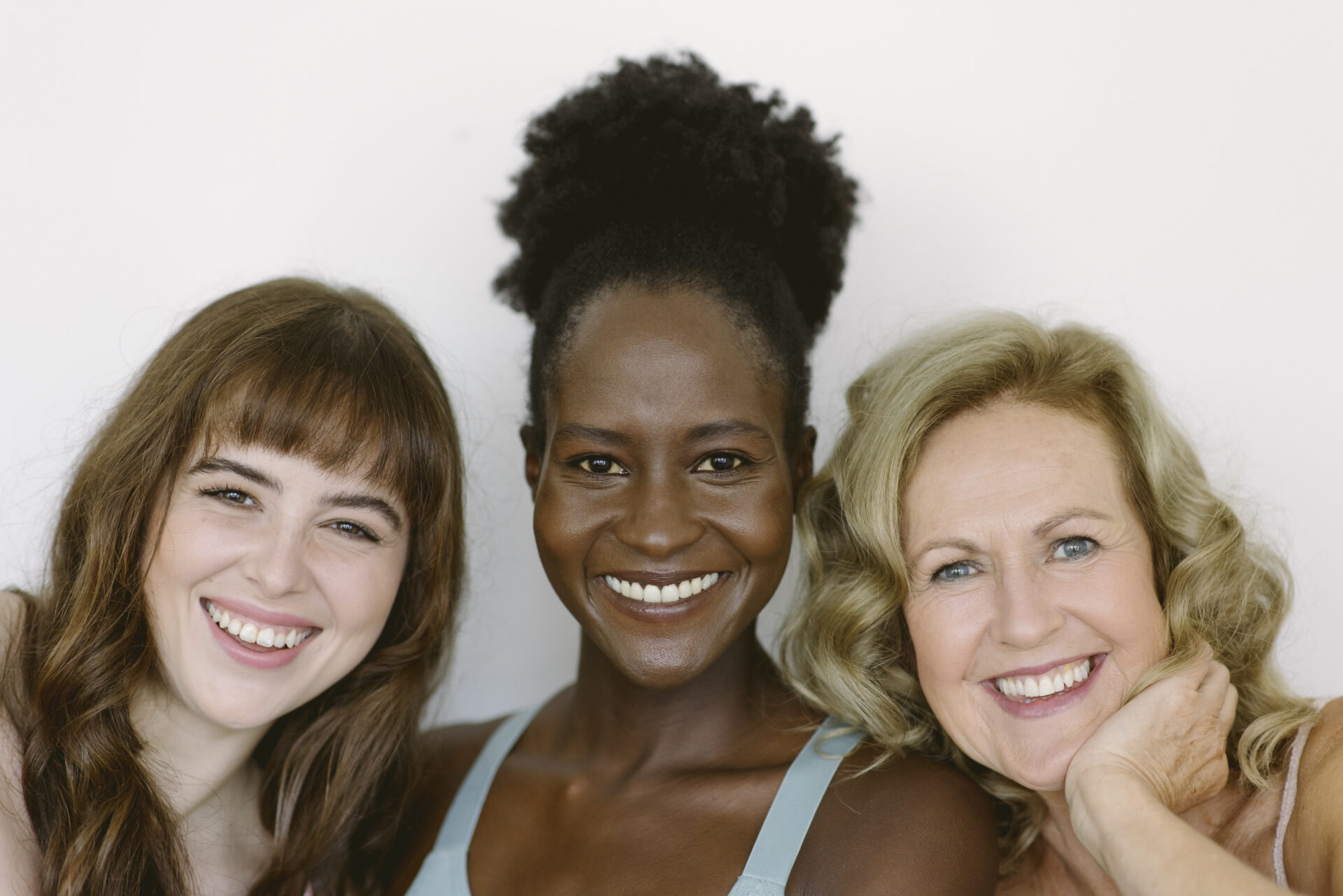 Drei Frauen fröhlich nebeneinander sitzend