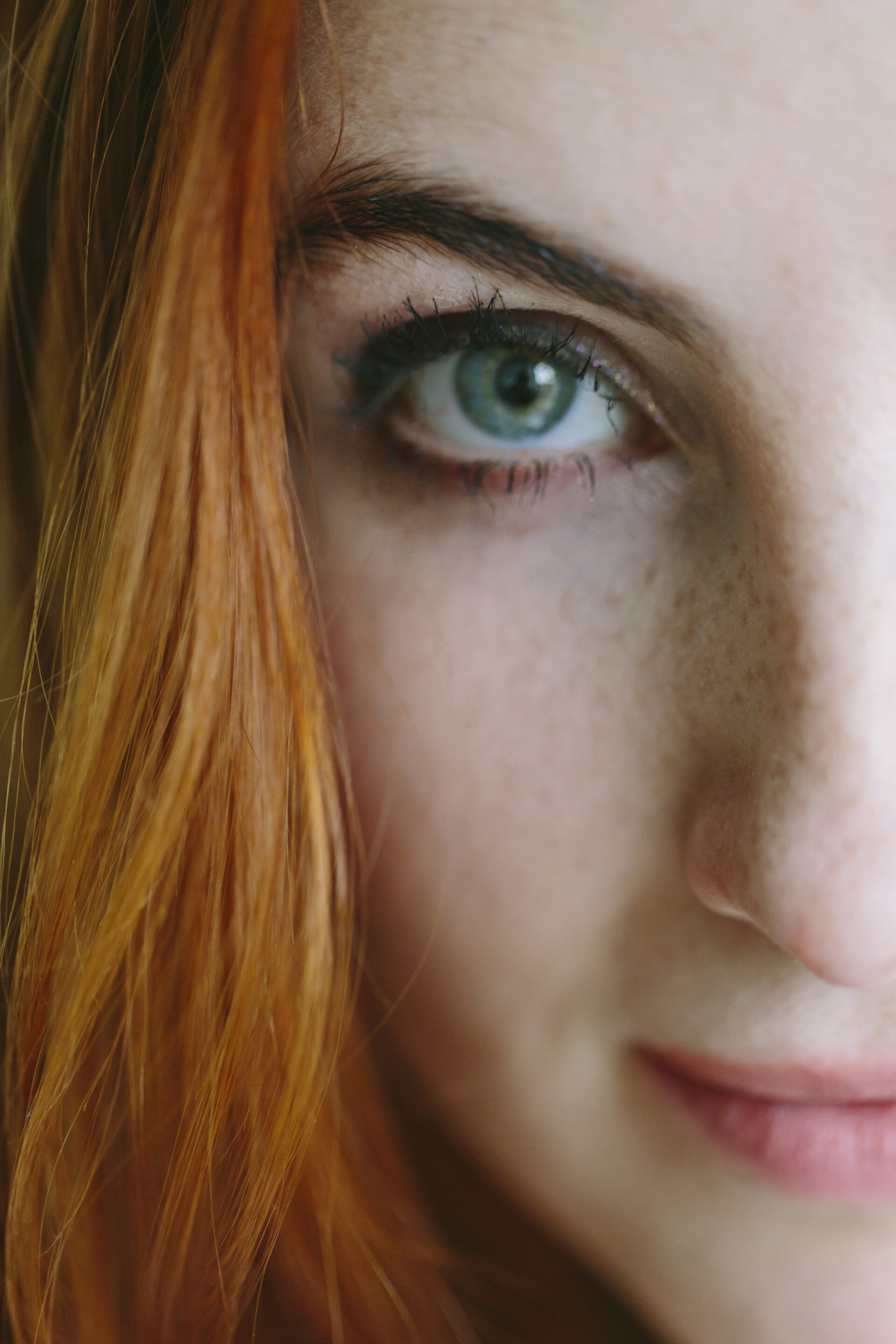 Nahaufnahme von linker Gesichtshälfte einer rothaarigen Frau